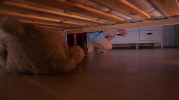 a little girl finds her favorite toy under the bed, own world of a small child video
