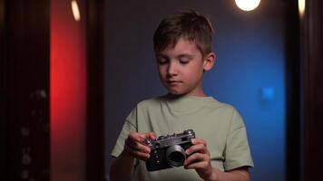 portrait de une garçon prise des photos sur un vieux ancien caméra video