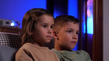 frère et sœur en riant et en train de regarder marrant film dans Accueil théâtre video