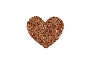 Flax seeds. Raw whole linseed in heart shape isolated on white background. photo