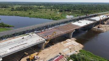 antenne visie van bouw plaats van een nieuw vervoer brug aan de overkant een breed rivier- video