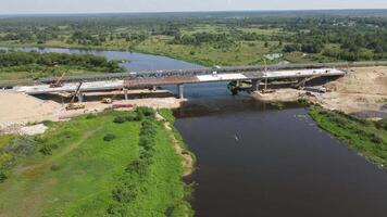 aérien vue de le construction de une Nouveau transport pont à travers une large rivière video