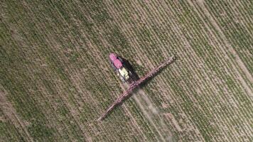 aerial top view red tractor sprayer works a field of young corn in a dry year video