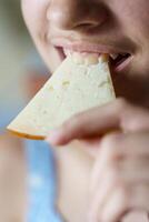 contento anónimo niña mordiendo Fresco queso rebanada foto