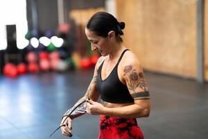 Woman protecting her wrists with wraps before training photo