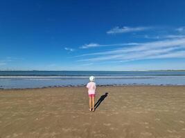 niña con sombrero en frente de el mar, en un arenoso playa. valdelagrana playa foto