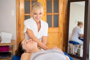 Smiling physiotherapist treating patient in hospital room photo