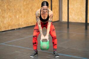 Woman working out using kettlebell in a gym photo