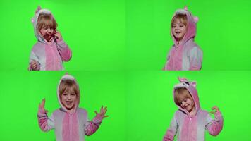 Child girl in unicorn pajamas making silly funny faces, fooling around, showing tongue on chroma key video