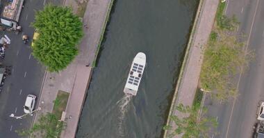 An aerial view of A Solar powered shuttle boat surfing on the canal at central of the city video