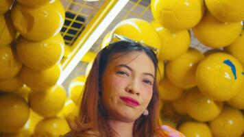kvinna leende i en rum fylld med gul bollar. video