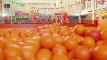 vivace arance su Schermo a un' mercato con festivo decorazioni nel il sfondo. video