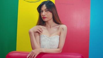 Confident young woman posing with a colorful background, showcasing beauty and style. video