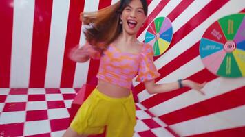 Stylish woman in vibrant summer outfit posing against a dynamic red and white striped background. video