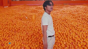 Person walking through a sea of oranges, contemplating the vast citrus abundance. video