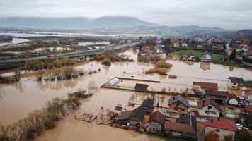 Aerial drone view of torrential rain causes flash floods in residential areas. Houses and roads surrounded by water. Climate change. Heavy rainfall consequences. photo