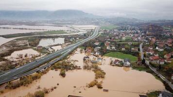 Aerial drone view of torrential rain causes flash floods in residential areas. Houses and roads surrounded by water. Climate change. Heavy rainfall consequences. photo