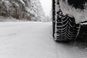 Car driving in the winter. Good winter tires for a safe grip. Careful driving in winter conditions. photo