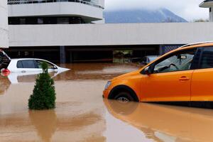 torrencial lluvia causas destello inundaciones en el ciudad área. carros debajo agua en el condominio estacionamiento lote. dañado carros causado por pesado lluvia. edificios rodeado por agua. foto