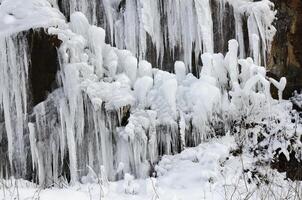 Ice stalactites. Hanging pointy ice. Frozen water. Background and textures. Winter. photo