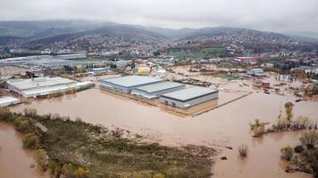 Torrential rain causes flash floods in the city area. Buildings surrounded by water. photo