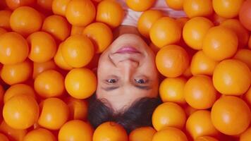 kind omringd door helder oranje ballen, speels en kleurrijk concept. video