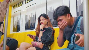 les passagers sur une métro former, un la personne à la recherche à une intelligent téléphone et un autre repos tête sur main, représentant Urbain navette. video