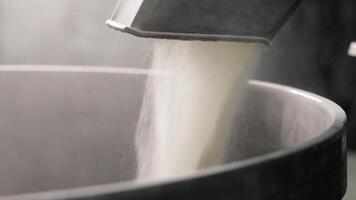 Process of sifting Flour for making Dough in Bakery. Measured Amount of Flour being poured into Large Mixing Bowl through Electrical Sifter Machine. Concept of making Bread video