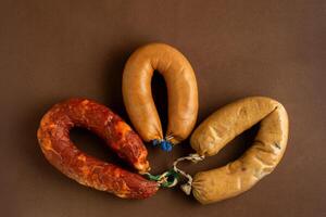 Traditional Portuguese sausages - linguica, farinheira, and alheira - displayed on a rustic brown background. photo