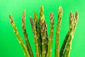 Vibrant green asparagus spears set against a lush green backdrop, showcasing freshness and nature's bounty. Ideal for culinary or wellness concepts. photo