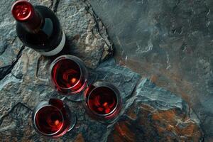 Red wine glasses and bottle on stone background. Top view with copy space Red wine glass photo