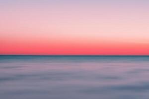 Serene Beachscape, Mirroring Soft Sand, Tropical Blur, and Abstract Sunset Sky. photo