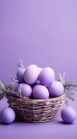 A basket of colorful eggs with copyspace on a purple background. Easter egg concept, Spring holiday photo