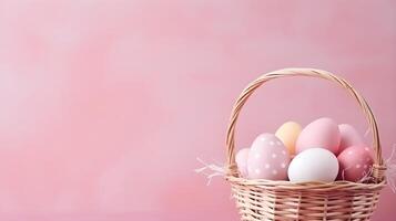 A basket of colorful eggs with copyspace on a pink background. Easter egg concept, Spring holiday photo