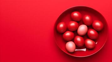 A bowl of colorful eggs with copyspace on red background. Easter egg concept, Spring holiday photo