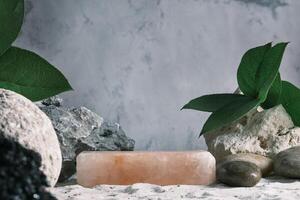 Background for cosmetic products grey concrete scene with himalayan salt and green leaves. Natural stone podium. Empty showcase for packaging product presentation. Mock up pedestal eco friendly photo