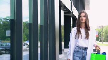 Young beautiful woman walking near the store with a package of food or clothes video