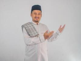 Moslem Asian man smiling and pointing both hands to the side photo