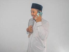 Moslem Asian man smiling happy while calling his family during Ramadan celebration photo