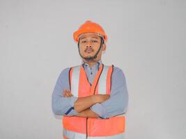 Asian constructor worker man with safety vest stand croosed his arm with confidence gesture photo