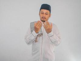 Moslem man smiling and looking above while doing praying pose photo