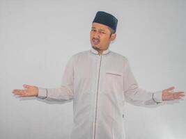 Moslem Asian man showing confused expression when trying to decide something photo