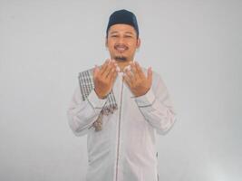 Moslem man smiling and looking above while doing praying pose photo