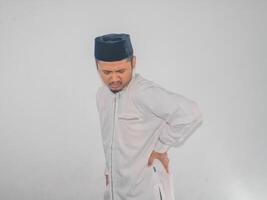 Muslim adult Asian man suffering from lower back pain photo