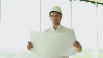 Engineer builder architect with safety helmet with drawing, looking on new building on site video