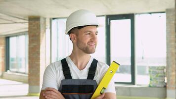 portrait de un ingénieur dans une casque avec Jaune équilibre règle à une construction placer. bulle niveau règle proche en haut voir, mesure et nivellement concept video