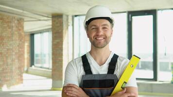 portrait de un ingénieur dans une casque avec Jaune équilibre règle à une construction placer. bulle niveau règle proche en haut voir, mesure et nivellement concept video