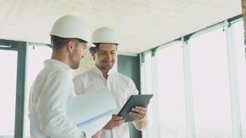 dos ingenieros discutir trabajo con un tableta a el construcción sitio video