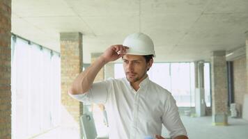 ingeniero desarrollador en casco inspeccionando edificio. arquitecto son caminando a lo largo el edificio en Progreso video