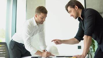 Engineer and architect reviewing office blueprints and technical drawings video